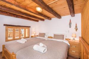 two beds in a bedroom with wooden ceilings at ARADENA TRADITIONAL House 3 in Arádhaina