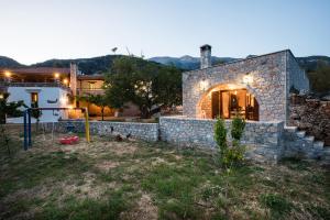 a stone house with a stone wall in a yard at ARADENA TRADITIONAL House 3 in Arádhaina +18 photos