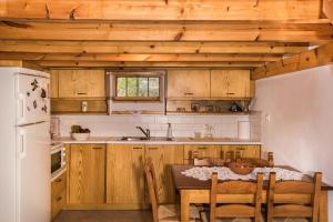 a kitchen with wooden cabinets and a table with chairs at ARADENA TRADITIONAL House 3 in Arádhaina