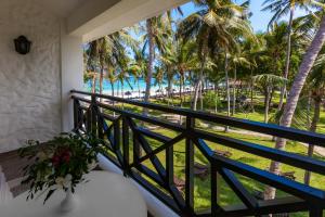 einen Balkon mit Blick auf das Meer und die Palmen in der Unterkunft Diani Sea Resort - All Inclusive in Diani Beach