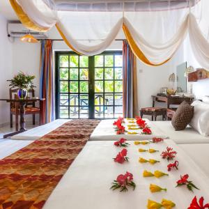 ein Zimmer mit 2 Betten mit Blumen darauf in der Unterkunft Diani Sea Resort - All Inclusive in Diani Beach