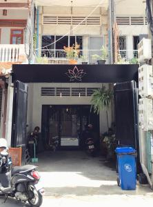 Sacred Lotus - Vegan Café X Hostel في بنوم بنه: دراجة نارية متوقفة أمام مرآب للسيارات