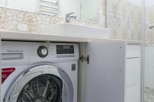 a washing machine in a bathroom with a sink at Apartments on Krasnaya Street in Minsk