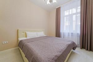sypialnia z łóżkiem i dużym oknem w obiekcie Apartments on Krasnaya Street w Mińsku