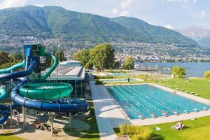 a pool with a water slide next to a swimming pool at Be easy In Selva in Locarno