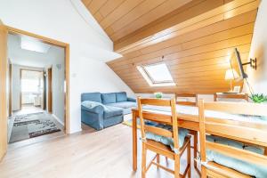 a dining room with a table and a blue couch at Privatzimmer mit eigenem Bad in Pattensen