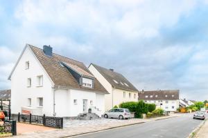 a white house with a car parked on a street at Privatzimmer mit eigenem Bad in Pattensen