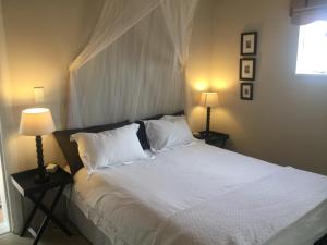 a bedroom with a bed with white sheets and two lamps at Fountain Place in McGregor