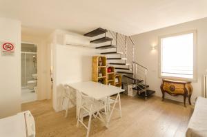 sala de estar con mesa y escalera de caracol en Appartamento del Nettuno en Bolonia