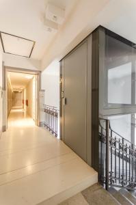 pasillo con puerta de cristal y escalera en Appartamento del Nettuno en Bolonia