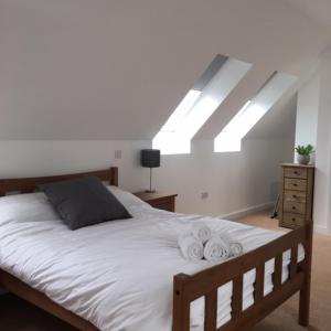 a bedroom with a large bed with white sheets at Tidemill House 5b Apartment in Falmouth