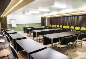 a classroom with tables and chairs in a room at Pensiunea Aria Paltinis in Păltiniş