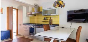 eine Küche mit einem weißen Tisch und einem TV in der Unterkunft Marjan Hill in Split