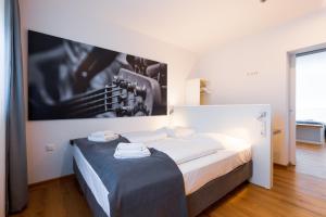 a bedroom with a bed with a large picture on the wall at mk hotel münchen max-weber-platz in Munich