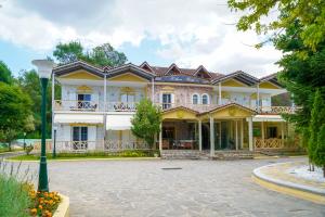 una grande casa gialla con un grande vialetto di Krikonis Hotel a Ioannina