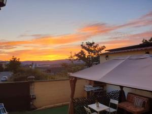 a sunset on the roof of a house with an umbrella at Sleeping Sarria in Sarria