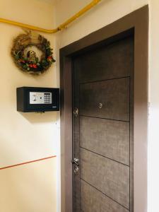 a door with a television and a wreath on the wall at Little cute homey apartman in Satu Mare