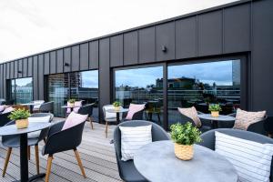 
a patio area with tables, chairs, and tables with umbrellas at PREMIER SUITES PLUS Antwerp in Antwerp
