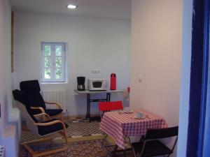 Habitación con mesa, sillas, mesa y microondas. en Casa Rural Ortulane, en Urduliz