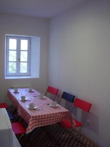 un comedor con una mesa con sillas rojas y azules en Casa Rural Ortulane, en Urduliz