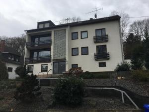 ein großes weißes Haus mit schwarzen Fenstern in der Unterkunft Seven in Koblenz