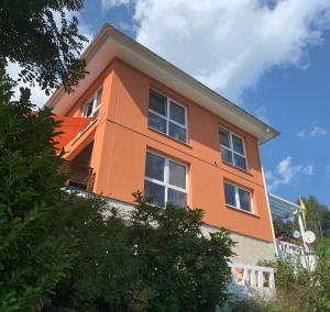 un edificio arancione con finestre bianche in cima di Ferienwohnung Drachennest mit Sonnenterrasse a Feldkirch