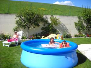two children playing in a pool in a backyard at Appartments Am Wiesenrand in Nova Ponente