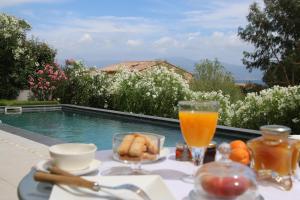 a table with a tray of food and a glass of orange juice at VILLA GOLFE AJACCIO près des plages in Ajaccio