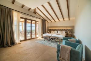 a bedroom with a bed and two chairs at Hotel Creu de Tau Art&Spa-Adults only in Capdepera +46 photos