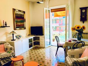 sala de estar con TV, mesa y sillas en Appartamento Andora mare, en Andora