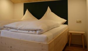 ガシュルンにあるMO Chaletのベッド(白いシーツ、枕付)