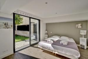 - une chambre avec un grand lit et une porte coulissante en verre dans l'établissement La Dependance by Cocoonr, à Bordeaux