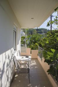 a patio with a table and chairs on a balcony at Golden Sun Apartments in Rovies