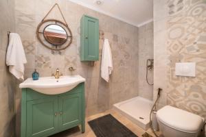 a bathroom with a sink and a toilet and a mirror at ARADENA TRADITIONAL House 4 in Arádhaina