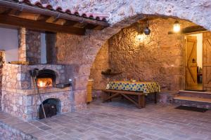 a stone room with a fireplace and a bench at ARADENA TRADITIONAL House 4 in Arádhaina