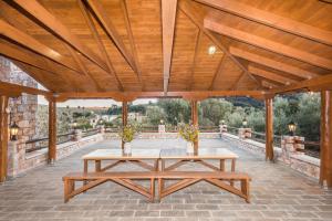 a wooden pavilion with a table on a patio at ARADENA TRADITIONAL House 4 in Arádhaina