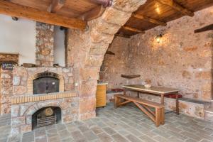 a stone walled room with a table and a fireplace at ARADENA TRADITIONAL House 4 in Arádhaina