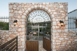 an entrance to a stone building with a gate at ARADENA TRADITIONAL House 4 in Arádhaina