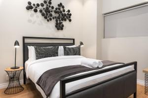 Schlafzimmer mit einem schwarzen und weißen Bett und einem Fenster in der Unterkunft The Docklands Luxury Apartments in Kapstadt