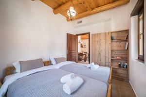 2 łóżka w sypialni z drewnianym sufitem w obiekcie ARADENA TRADITIONAL House 4 w mieście Arádhaina