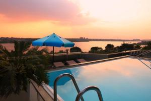 een zwembad met een parasol en uitzicht op het water bij Holiday Inn Cairo Maadi, an IHG Hotel in Caïro