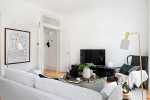 ein Wohnzimmer mit einem weißen Sofa und einem Tisch in der Unterkunft ALTIDO Downtown Bliss Apartments in Lissabon