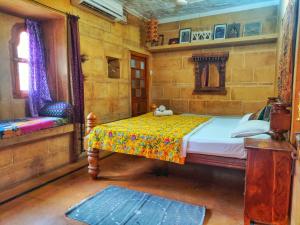 a bedroom with a bed and a chair in it at Shahi Palace Hotel Jaisalmer in Jaisalmer