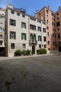 a large white building in front of some buildings at Corte Barozzi Venice Suites in Venice