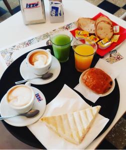 una mesa con una bandeja de alimentos y bebidas para el desayuno en Colonna 18, en Roma