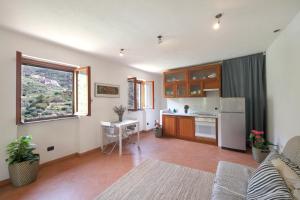 a living room with a kitchen and a table in it at FIESSE COTTAGE in Manarola