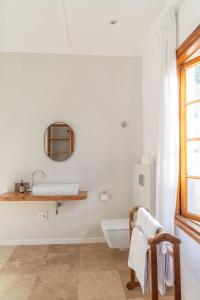 a white bathroom with a sink and a tub at Chartfield Guesthouse in Kalk Bay