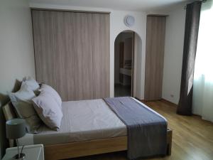 una camera da letto con letto, lenzuola e cuscini bianchi di Villa Le Clos Fleuri a Narbonne