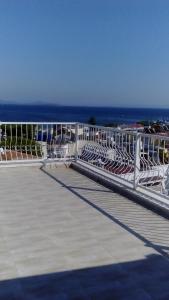 a white railing on a boardwalk with the ocean in the background at ÇİÇEK APART OTEL in Didim