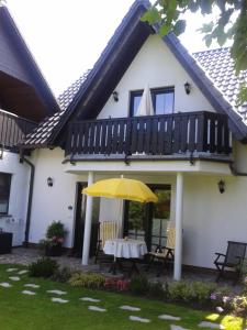 ein Haus mit einem Tisch und einem gelben Regenschirm in der Unterkunft Haus Kollwitzweg - Ferienwohnungen in Goslar